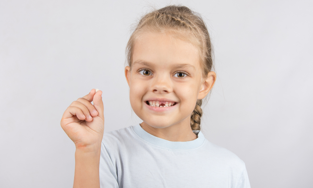 Como tirar um dente de leite mole?
